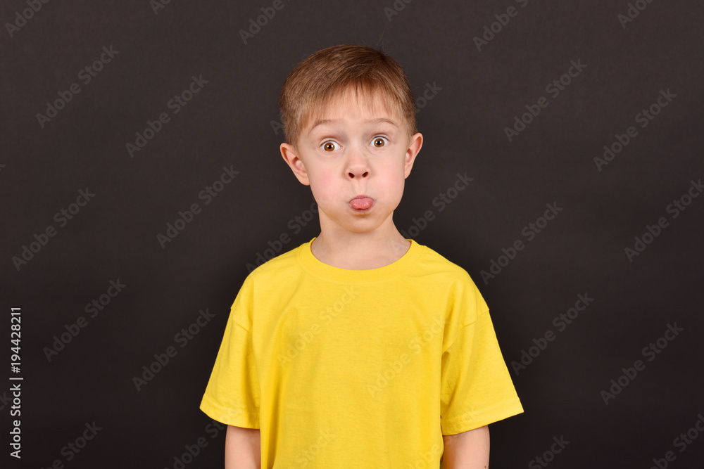 Portrait of a boy on a black background.Friend in a yellow T-shirt. Portrait of a boy on a black background.Friend in a yellow T-shirt.