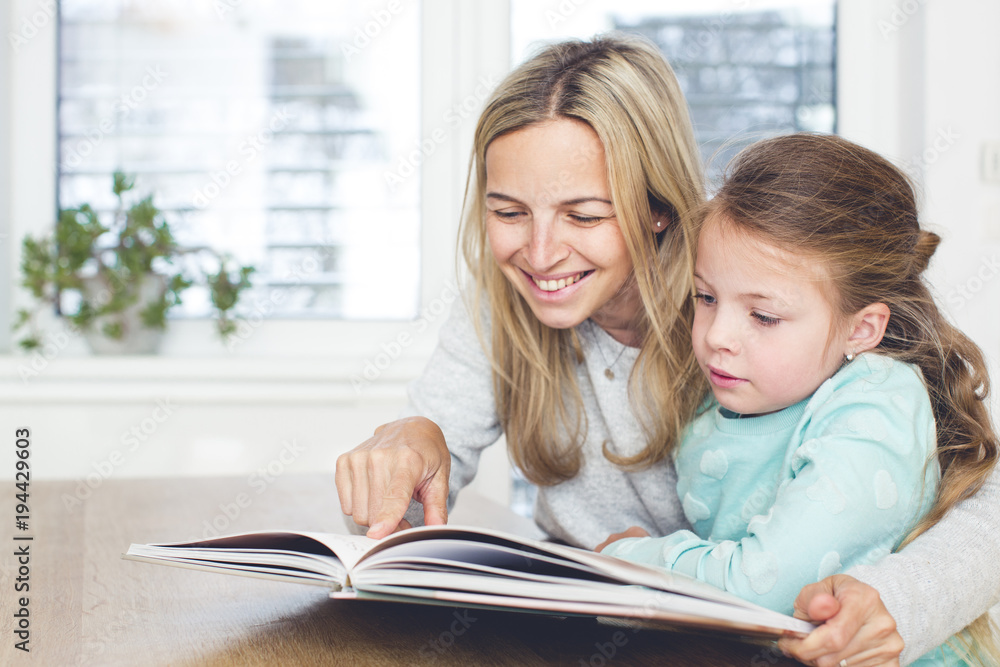 Mother is reading a book with the child Mother is reading a book with the child