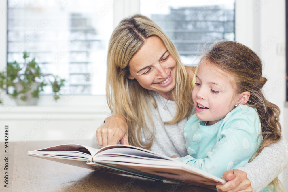 Mother is reading a book with the child Mother is reading a book with the child