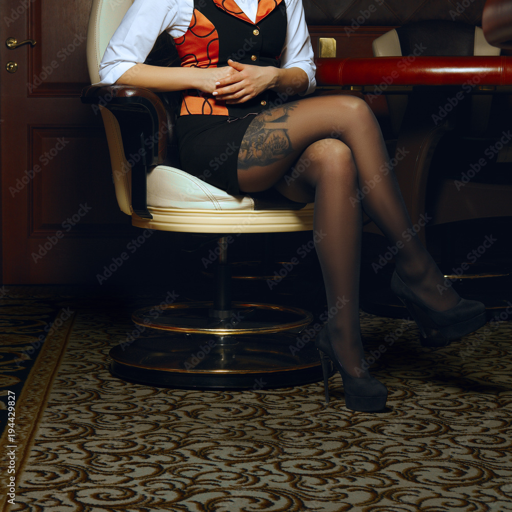 Sexy legs of casino croupier in armchair foto de Stock | Adobe Stock