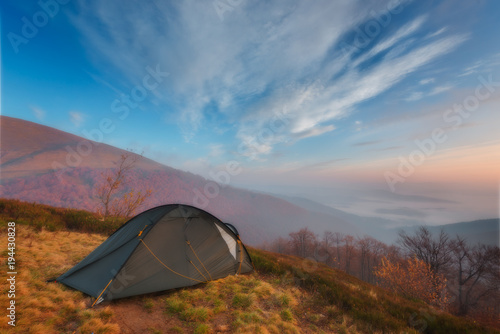 Tourist tent in camp among meadow in the mountain at sunrise.Tourist camp in a mountains. Carpathian  Ukraine  Europe. Beauty world.