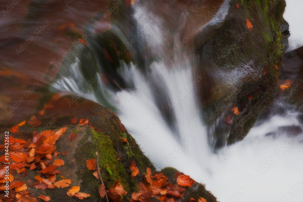 small waterfall i the autumn forest