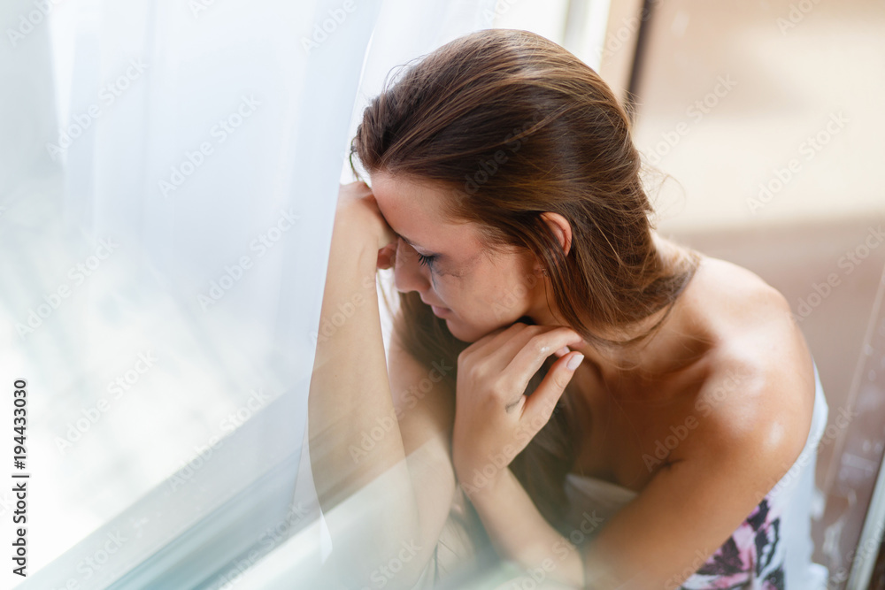 Girl with blurred makeup tears crying in the corner. Depression and stress woman portrait. Broken heart woman crying alone near the window, the concept of Valentine's Day. Girl with blurred makeup tears crying in the corner. Depression and stress woman portrait. Broken heart woman crying alone near the window, the concept of Valentine's Day.