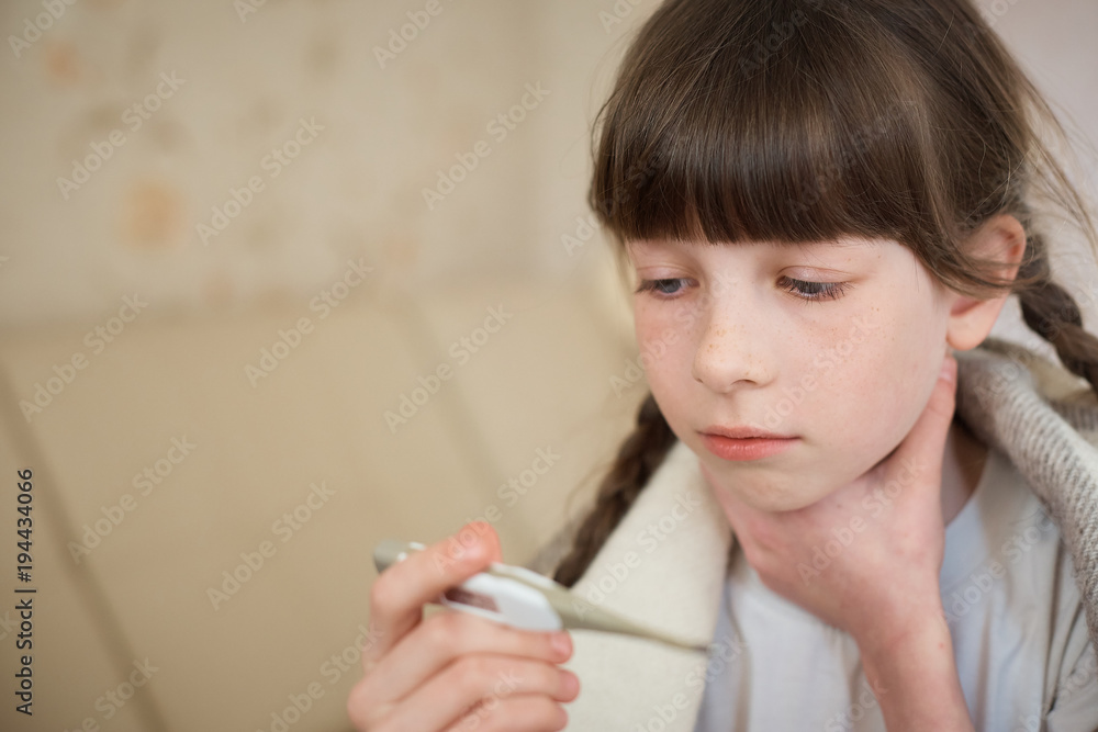Little baby girl in pink bathrobe holding a digital thermometer with high temperature, close-up shot Little baby girl in pink bathrobe holding a digital thermometer with high temperature, close-up shot