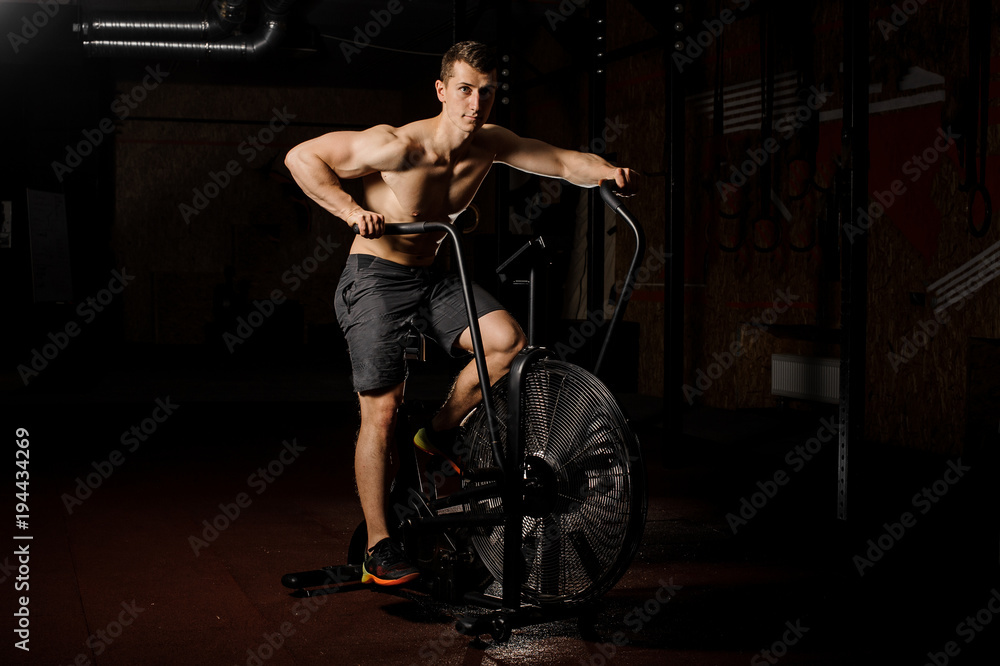 Young and handsome man practicing crossfit using an exercise equipment in a gym Young and handsome man practicing crossfit using an exercise equipment in a gym