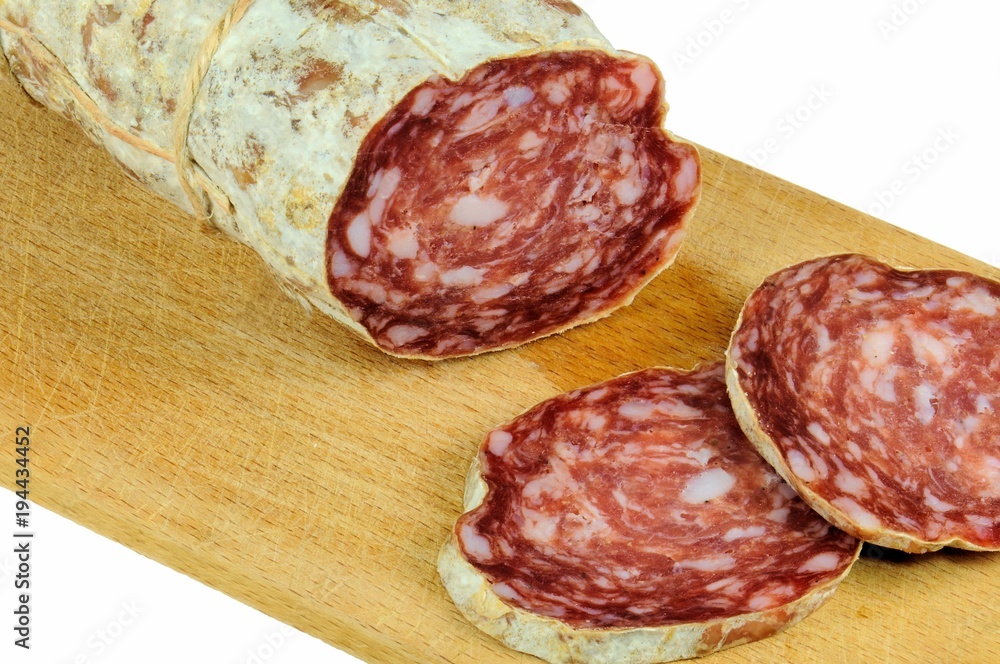 Pork salami with slices on wooden background.