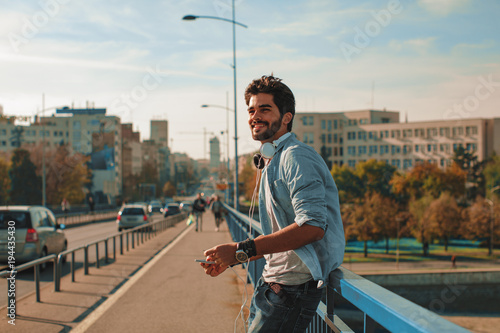 Young happy man using a smartphone  in the city