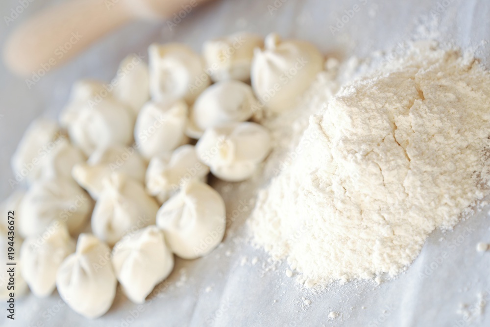 Homemade dumplings and flour on the table