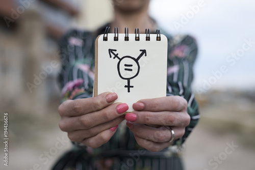woman shows notepad with a transgender symbol