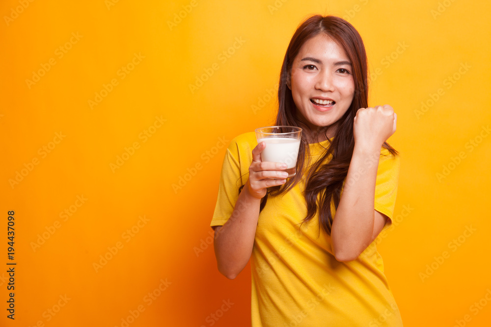 Healthy Asian woman drinking a glass of milk in yellow dress Healthy Asian woman drinking a glass of milk in yellow dress