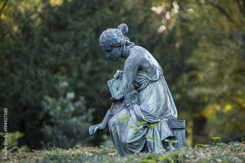 Stone statue of a woman at a graveyard
