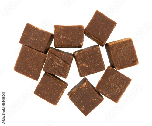 Top view of several chunks of butter chocolate fudge isolated on a white background.