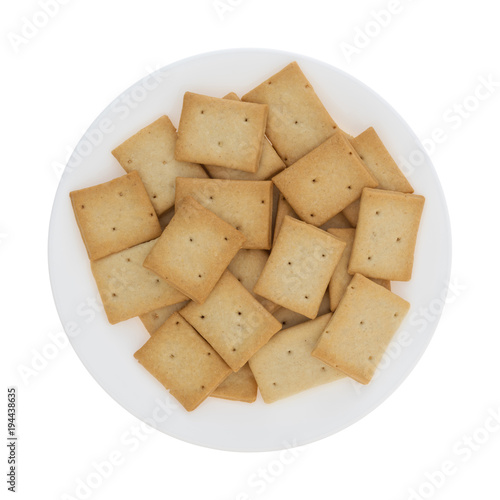 Top view of a plate filled with hard bread crackers isolated on a white background.