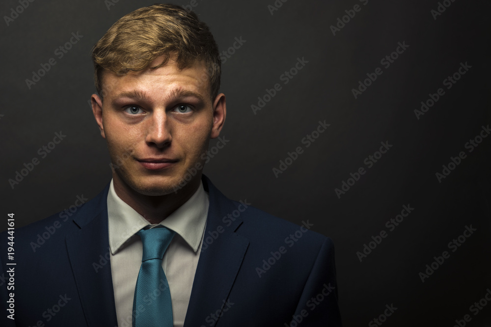Businessman in suit over dark background portrait. Businessman in suit over dark background portrait.