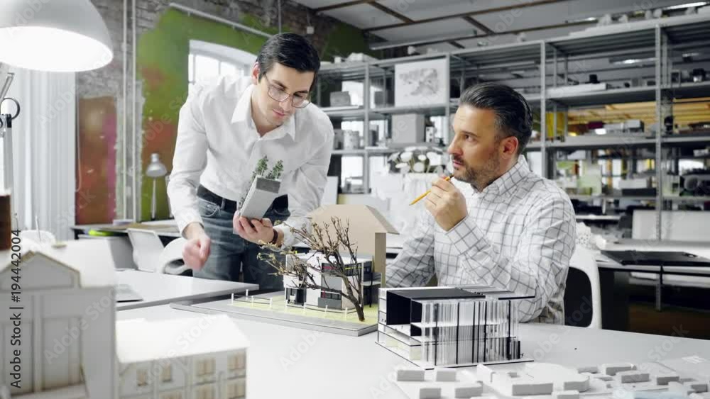 Two men working in design and engineering architecture office. Two men working in design and engineering architecture office.