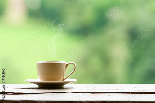 hot coffee with steam with green nature background