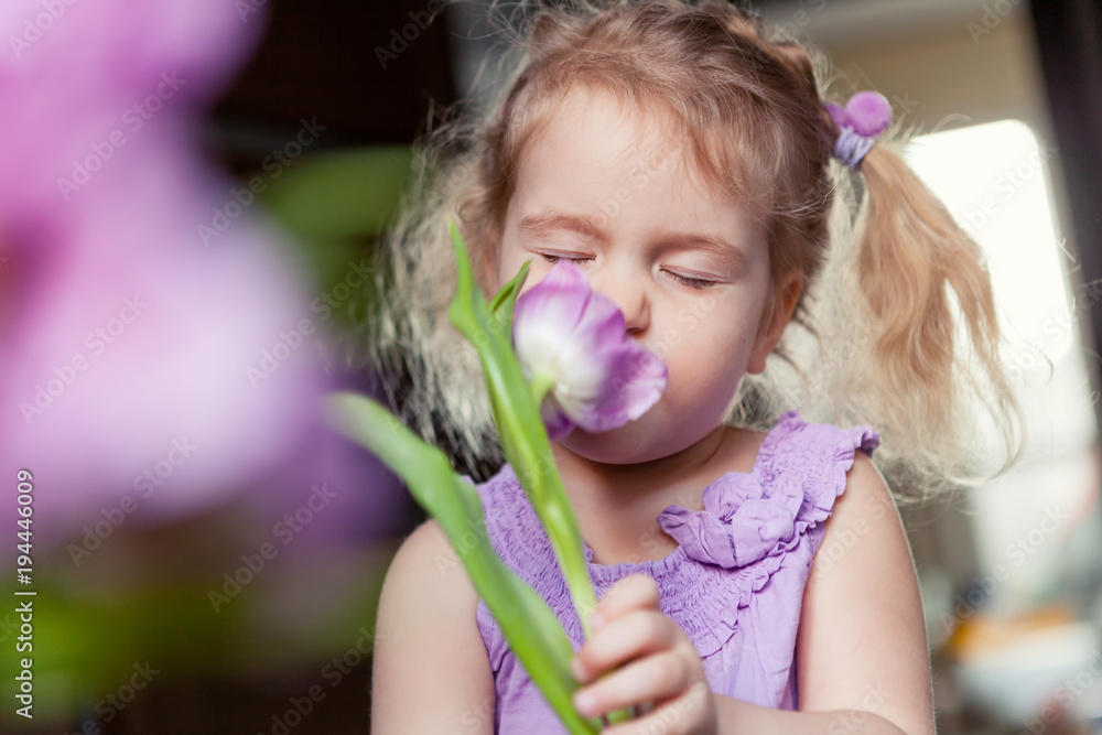 Portrait of beautiful little girl with bouquet of purple flowers. Portrait of beautiful little girl with bouquet of purple flowers.