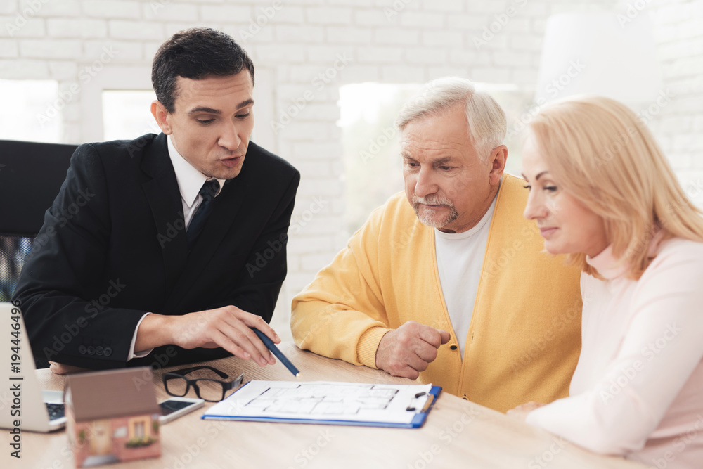 Fototapeta premium A couple of old people came to a consultation with a realtor. They listen attentively to everything that a realtor says.