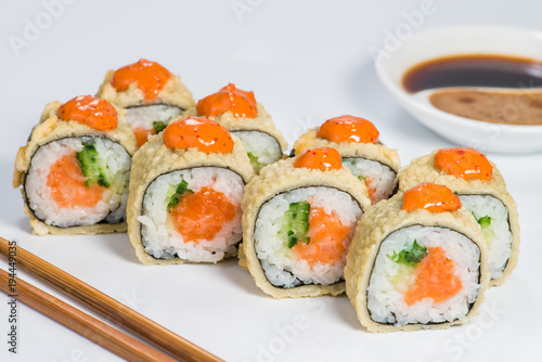 Japanese cuisine. Appetizing set of maki sushi rolls with rice, salmon, cucumber and sauce on light background