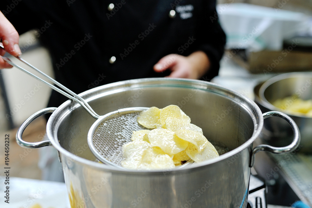 Chef cooking delicious french fries in a pot Chef cooking delicious french fries in a pot