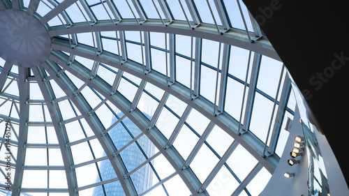 Glass dome of a modern building. View from the inside of the room. Light construction of transparent roof made of round steel tubes. Architectural background. Glass dome from inside at skyscrapper