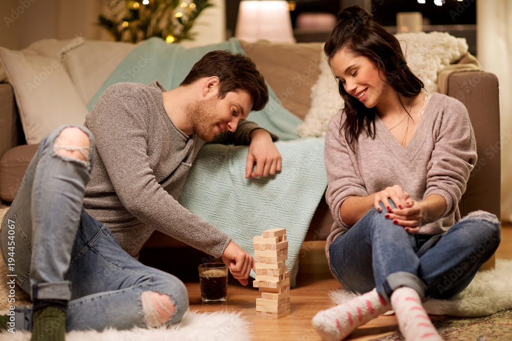 happy couple playing block-stacking game at home happy couple playing block-stacking game at home