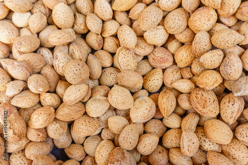 group of almond nuts in peel, natural food background