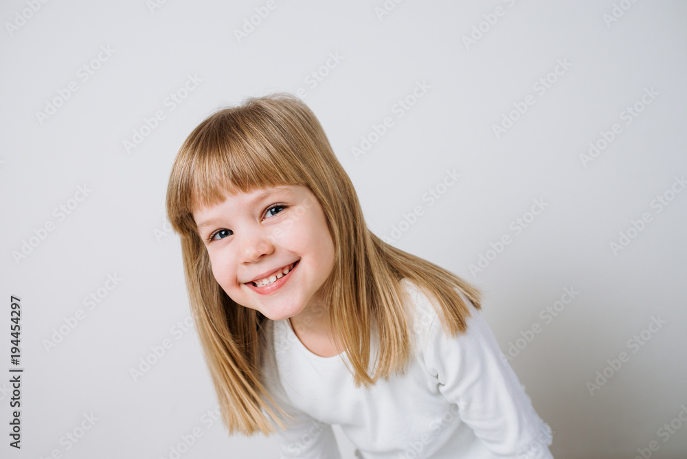 Close-up image of a smiling little girl on white background. Close-up image of a smiling little girl on white background.