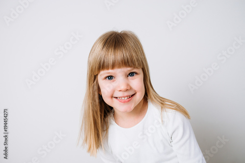 Portrait of a blonde little girl on white background.