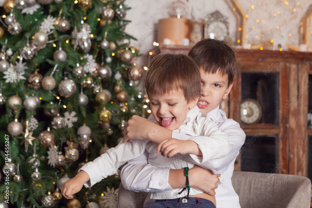Two brothers are playing near New Year tree. Two brothers are playing near New Year tree.
