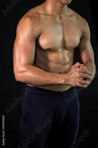 Close up bodybuilder muscular beautiful body on black background