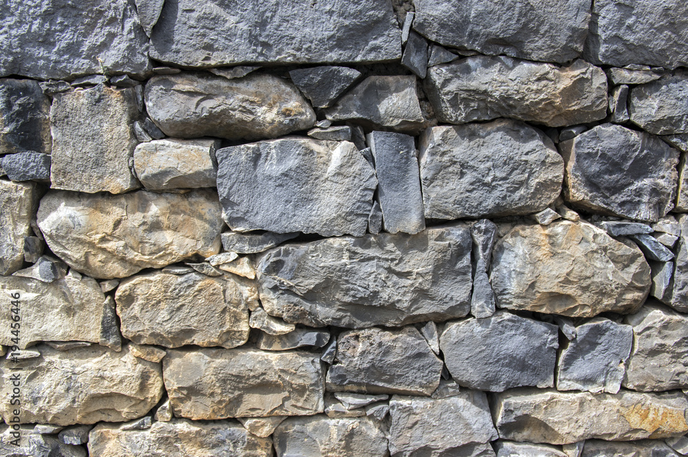 Detail of a wall made of stones, stone background, wall, pavement, grey and brown dark colors Detail of a wall made of stones, stone background, wall, pavement, grey and brown dark colors