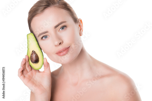 Portrait of woman with clean skin holding avocado isolated on white