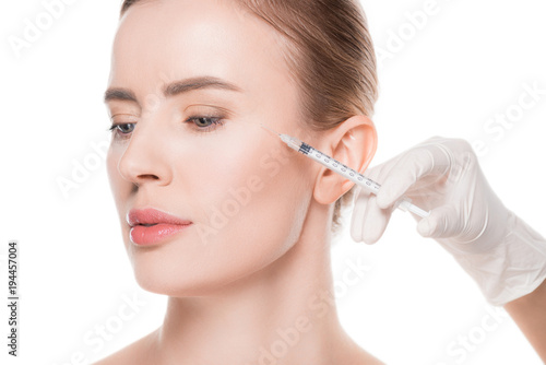 Beautician hands doing injection in woman cheek isolated on white