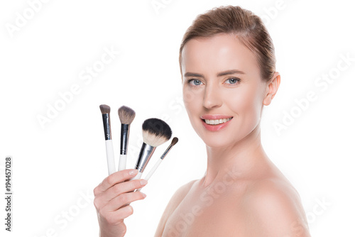 Smiling woman with cosmetic brushes isolated on white