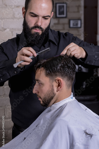 Hairdresser cutting a client's hair with a razor