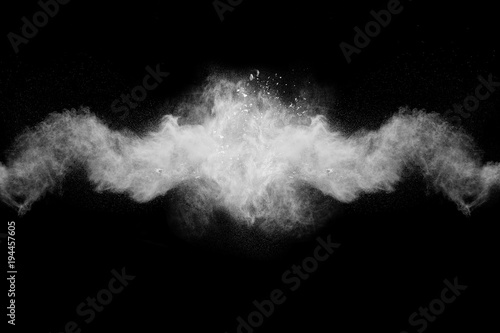 Launched white particle splash on black background. Bizarre forms of of white powder explosion cloud against dark background.