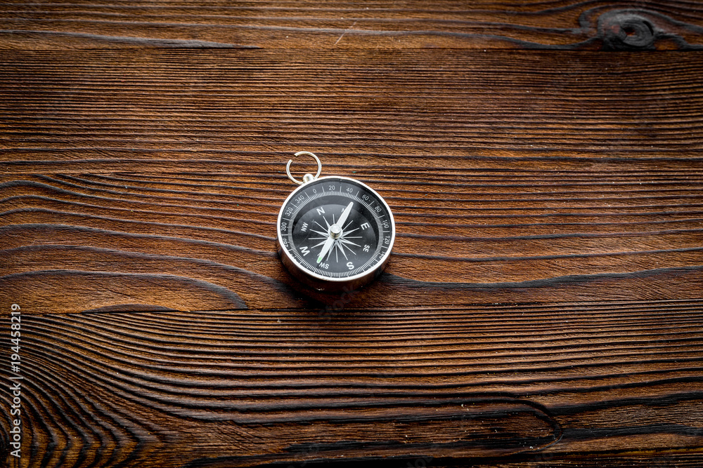 Compass on dark wooden background top view copy space