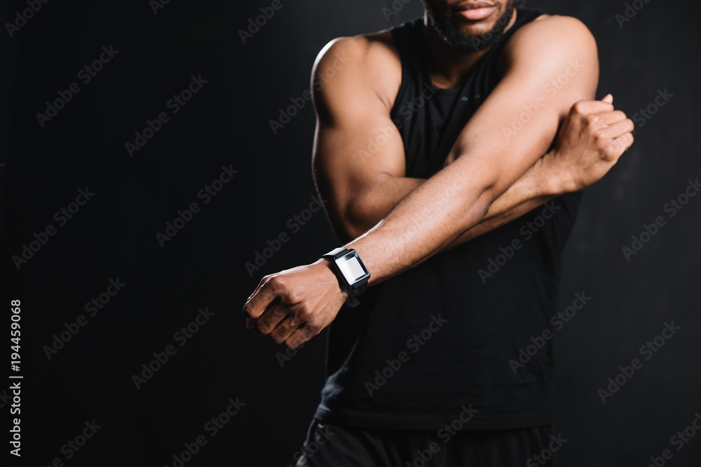 cropped shot of muscular african american man stretching hands isolated on black