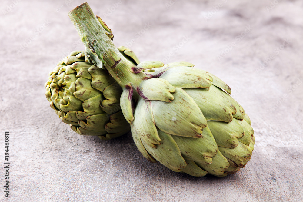 Fototapeta premium artichokes on grey background. fresh organic artichoke flower.