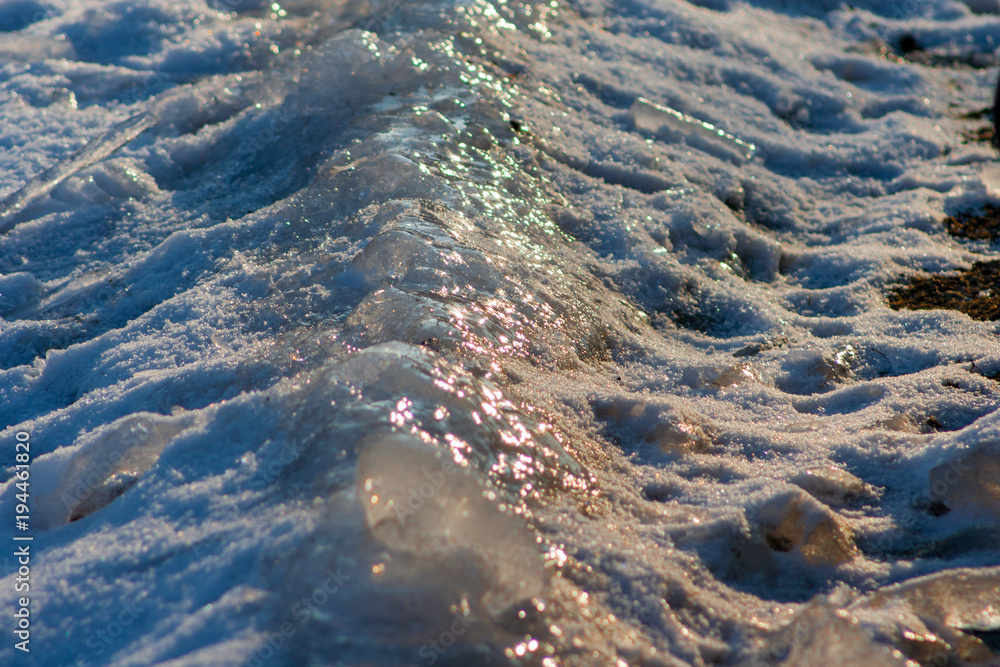 lying on the ground, snow and ice. The sun reflects off the ice.