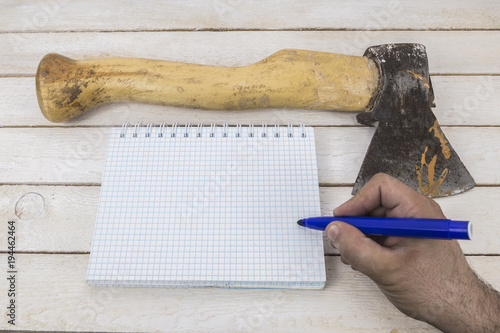 Hand writing on blank notepad near the Ax. suicide note photo