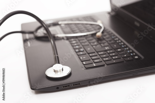 closeup of stethoscope on laptop. concept of PC service and technology