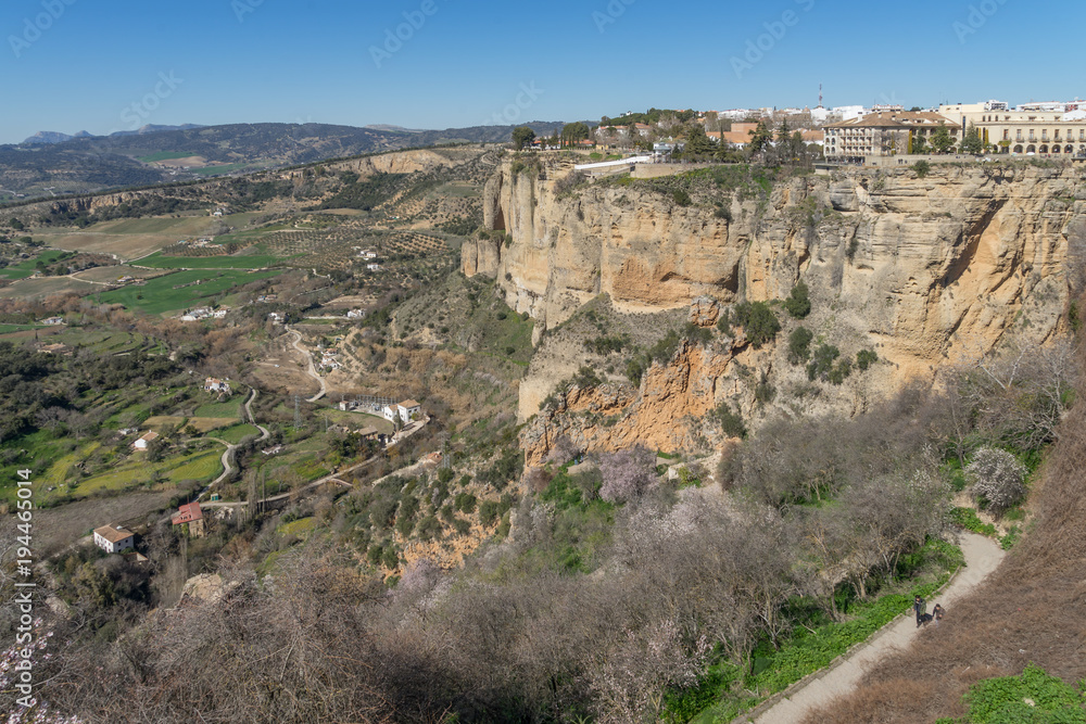 Ansicht der Stadt Ronda auf einem Berggipfel mit Wanderwegen im Vordergrund