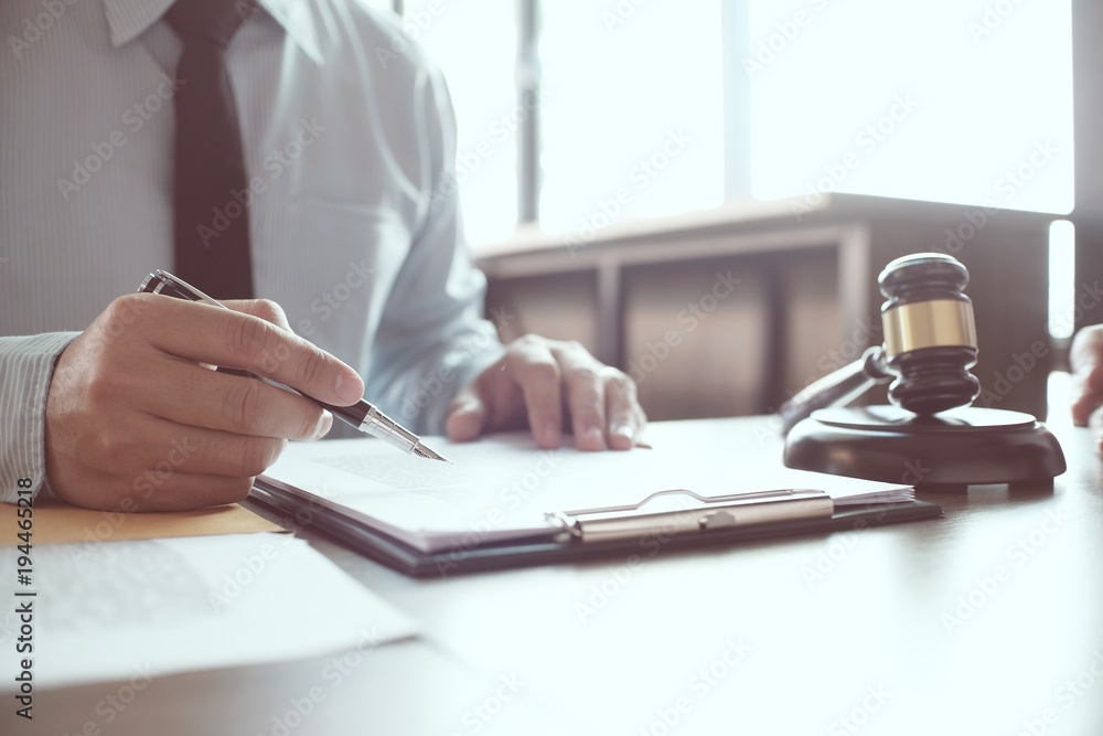 Legal counsel presents to the client a signed contract with gavel and legal law. justice and lawyer concept. Legal counsel presents to the client a signed contract with gavel and legal law. justice and lawyer concept.