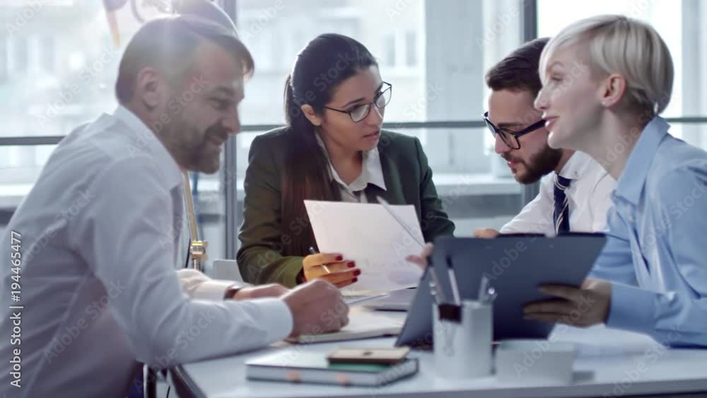 Tracking shot of business professionals working in team and discussing financial documents at office meeting Tracking shot of business professionals working in team and discussing financial documents at office meeting