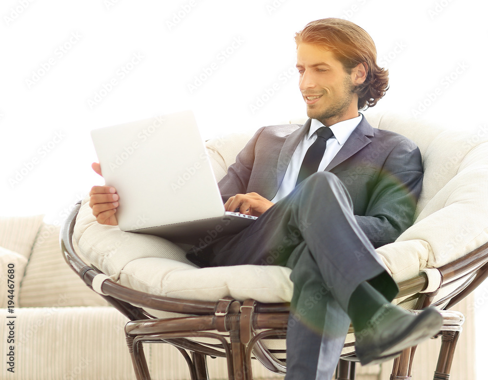 modern businessman with a laptop sitting in a stylish comfortabl