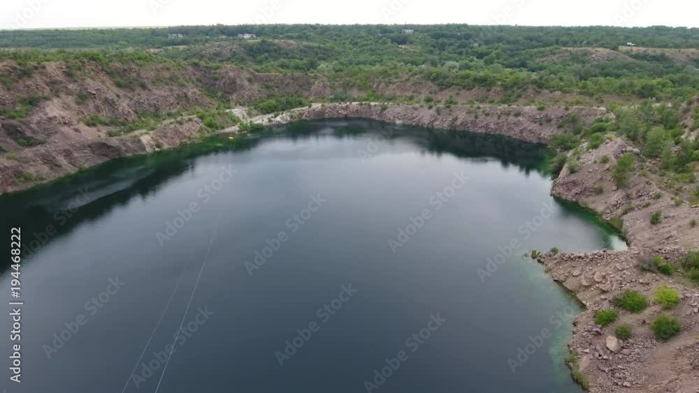 A fabulous view of a picturesque lake with high banks covered with sand, stones and grass in Ukraine on a sunny day in summer. A fabulous view of a picturesque lake with high banks covered with sand, stones and grass in Ukraine on a sunny day in summer.