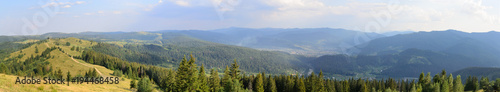 Panorama in beautiful mountains covered with forests and meadows trail to the horizon