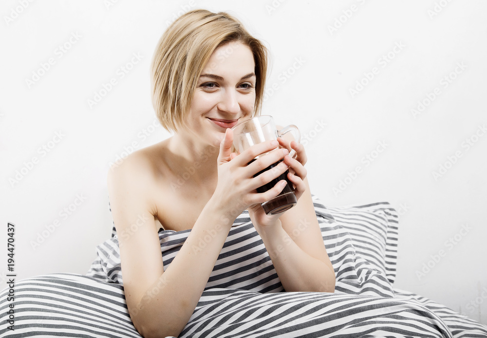 The girl drinks coffee in bed. Morning girl The young girl wakes up in the morning. Sleep. Morning awakening. Reading the press in bed. Under the blanket. The girl drinks coffee in bed. Morning girl The young girl wakes up in the morning. Sleep. Morning awakening. Reading the press in bed. Under the blanket.